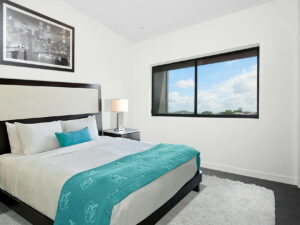 white bedspread and black wooden bed