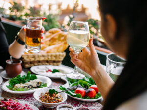 women-holding-glasses-with-lemonade-table-with-different-dishes