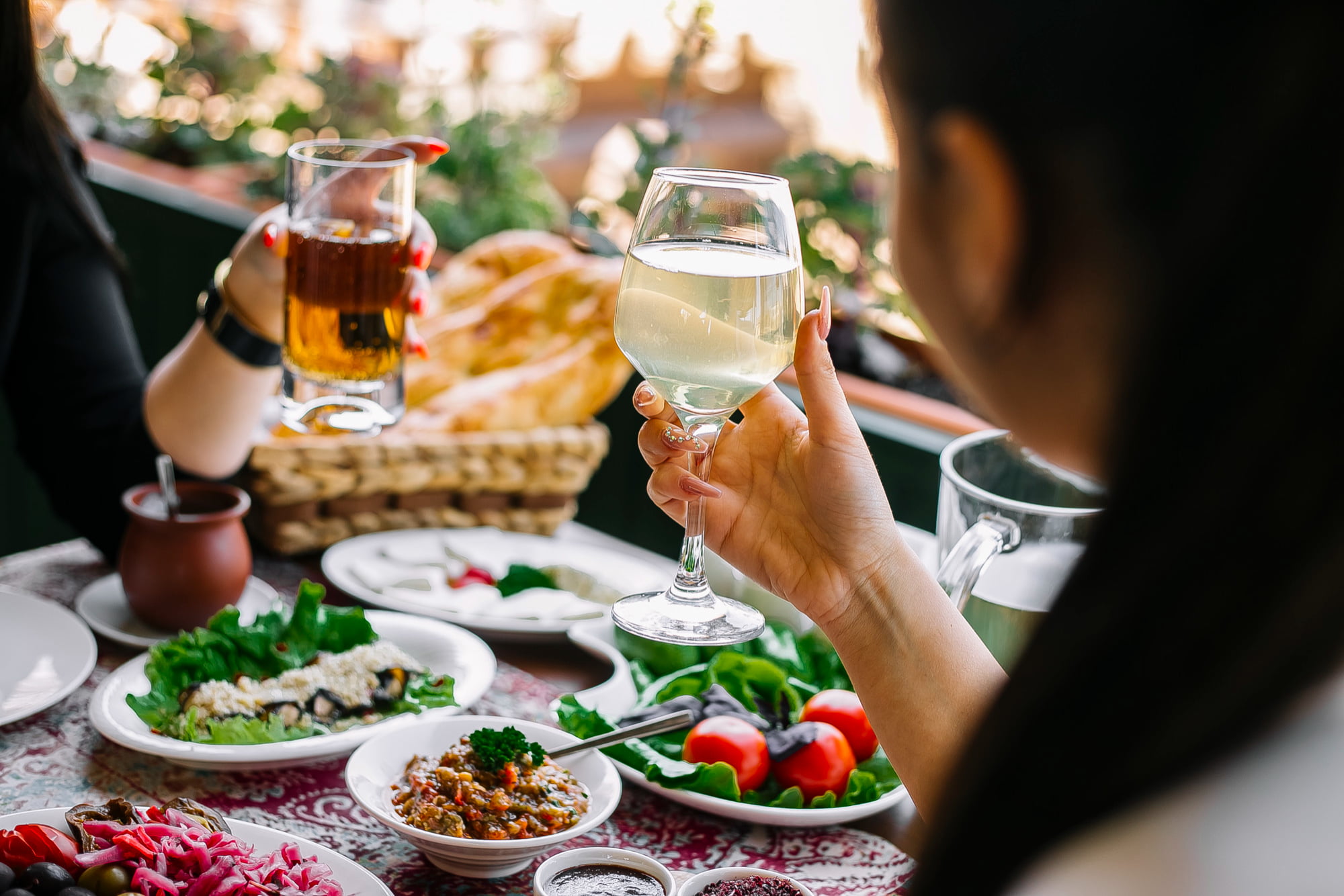 women-holding-glasses-with-lemonade-table-with-different-dishes